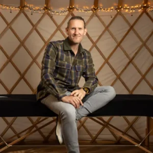 Wouter Breukers van Oerwout zit op een massage tafel en kijkt in de camera